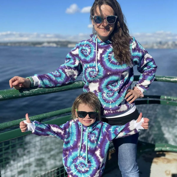 Duo sweat TITUS pour adultes (XS - XXXL) et enfants (2 - 16 Ans) en mer, portant des sweats assortis avec motif spirale colorée.