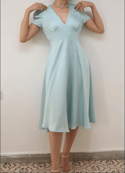 Femme portant la FAYA ROBE-taille de 30 à 58 EU, élégante robe bleue inspirée des années 40, patron de couture pdf à télécharger.