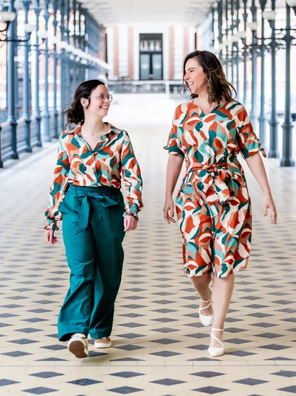 Deux femmes portant FIGUE - La blouse parfaite avec un patron de couture pdf à télécharger, en marchant dans un hall élégant.