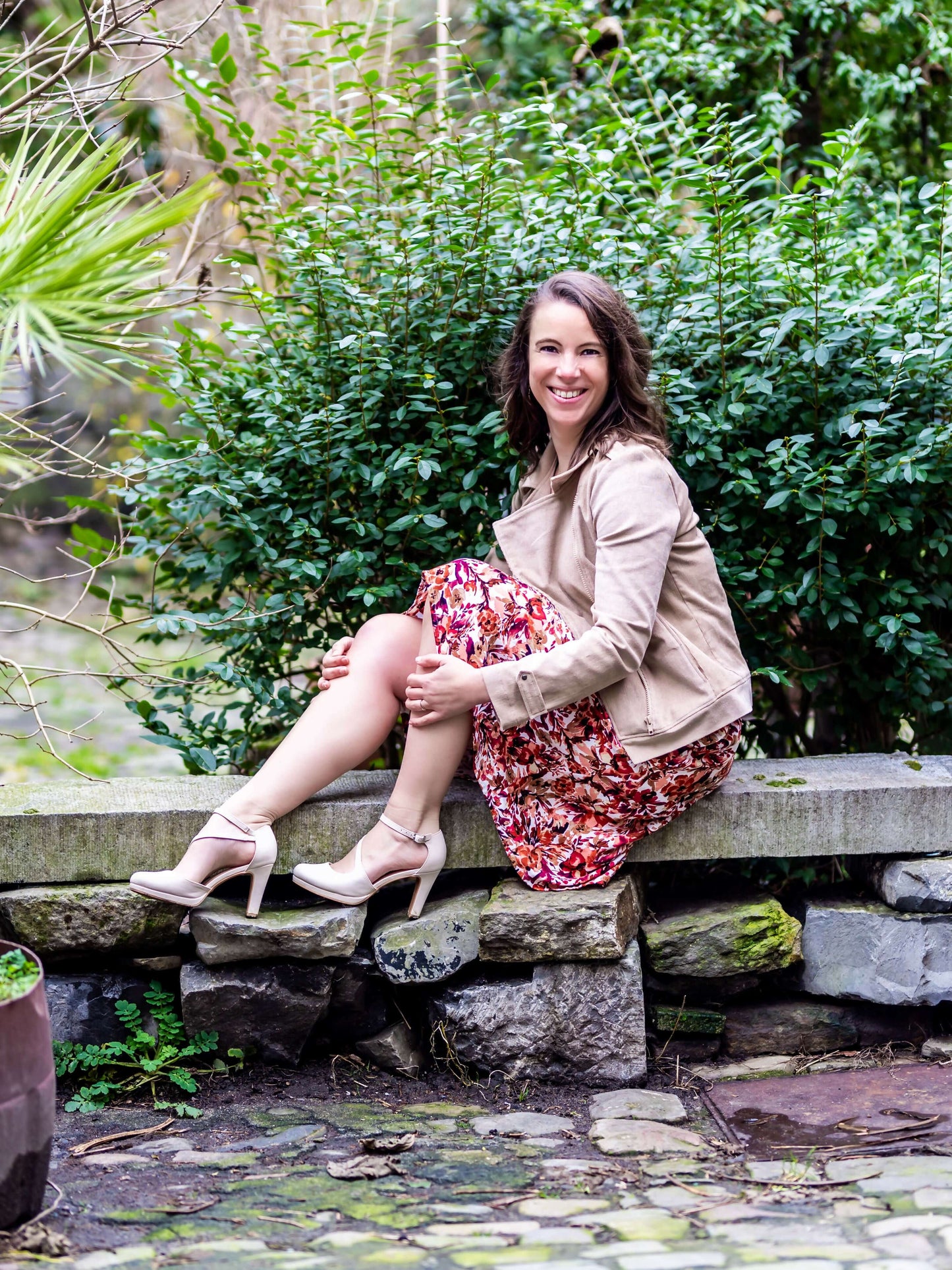 Femme portant FRAMBOISE - Le perfecto en simili cuir, assise sur un banc dans un jardin, patron de couture pdf à télécharger.