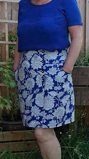 Jupe bleue à motif floral portée dans un jardin, exemple de Jupe Améthyste avec patron de couture pdf à télécharger.