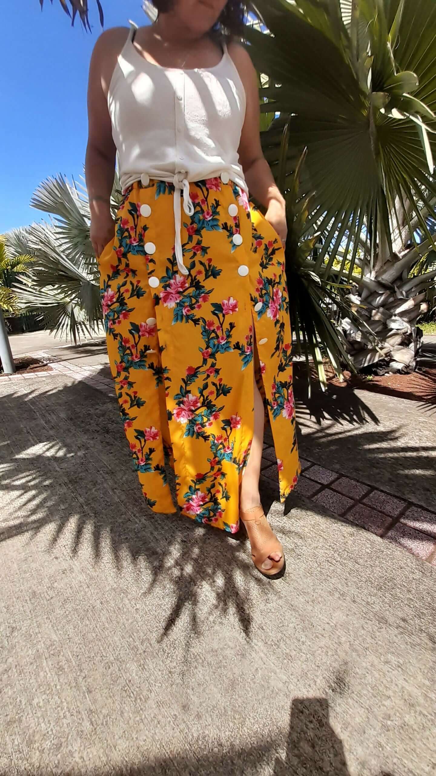 Femme portant la Jupe Astéria - T36 à 50 avec motif floral lumineux, patron de couture pdf à télécharger, sous un ciel ensoleillé.