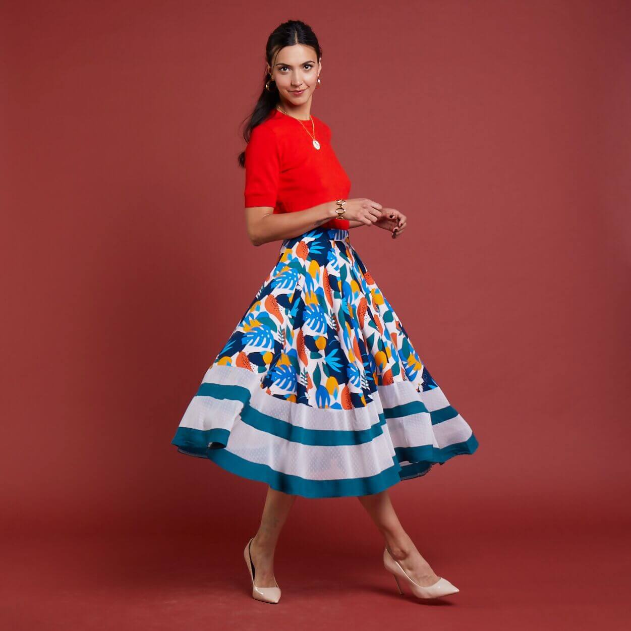 Femme portant la Jupe La Prodigieuse - T34 à 48, patron de couture pdf à télécharger, dans un cadre festif et coloré.