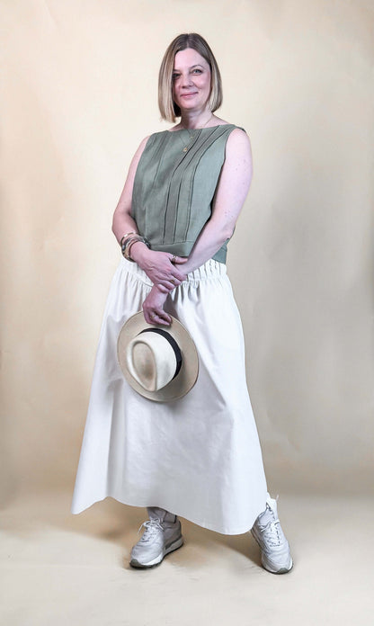 Modèle féminin portant une Jupe Lola, patron de couture pdf à télécharger, avec un haut vert kaki et des baskets blanches.