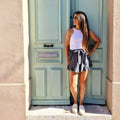 Femme portant Jupe / Short Bibiche - T34 à 48 avec patron de couture pdf à télécharger, devant une porte verte.
