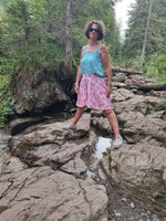 Femme en jupe-short LILAS, posant sur des rochers, parfait pour l'été, alliant confort et élégance.