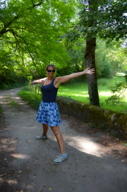 Femme portant une jupe-short bleue floral, profitant d'une journée ensoleillée dans la nature.