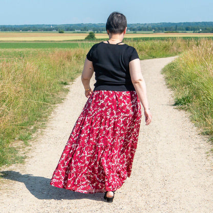 Jupe bohème Mirabelle portée, patron de couture PDF à télécharger, vue de dos avec volants et motifs floraux, nature en arrière-plan.
