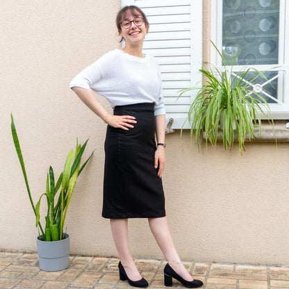 Femme portant une Jupe crayon, 34 au 56, 4 statures - Marjolaine, devant une maison avec plantes, patron de couture pdf à télécharger.