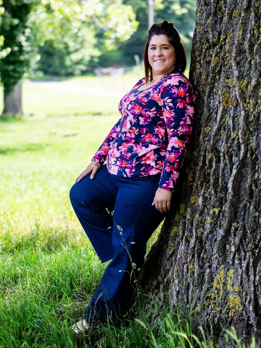 Femme portant un pantalon chino, posant contre un arbre, illustrant le KAKI - Le pantalon chino, patron de couture pdf à télécharger.