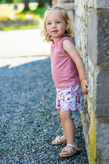 Enfant portant un short fleuri et un débardeur rose, illustrant KUMQUAT - Le short / bermuda / pantalon, patron de couture pdf à télécharger.