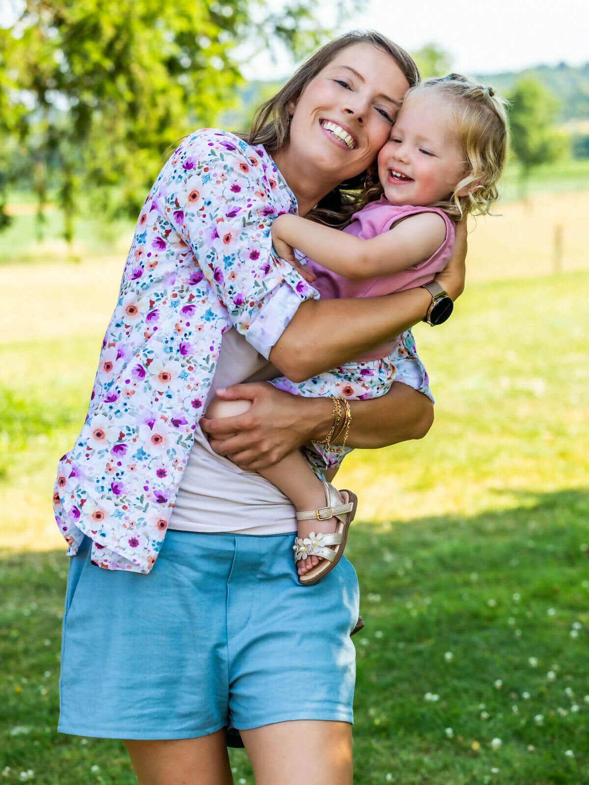 Mère et enfant souriants profitant d'une journée ensoleillée, la mère porte le KUMQUAT - Le short / bermuda / pantalon, patron de couture pdf à télécharger.