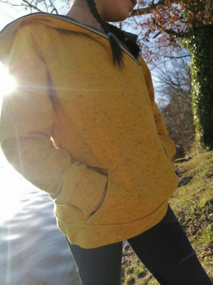 Jeune portant LE SWEAT ZIP ZAG 6-16 ans avec poches kangourou, design original et zip diagonal au bord de la capuche.