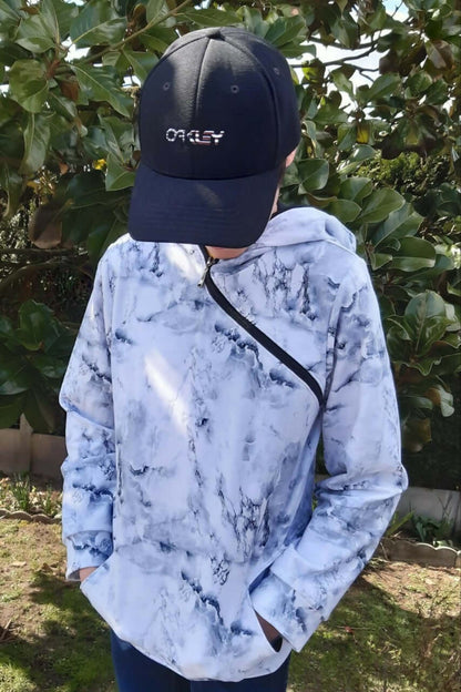 LE SWEAT ZIP ZAG 6- 16 ans porté par un jeune avec un casquette Oakley, style original et décontracté.