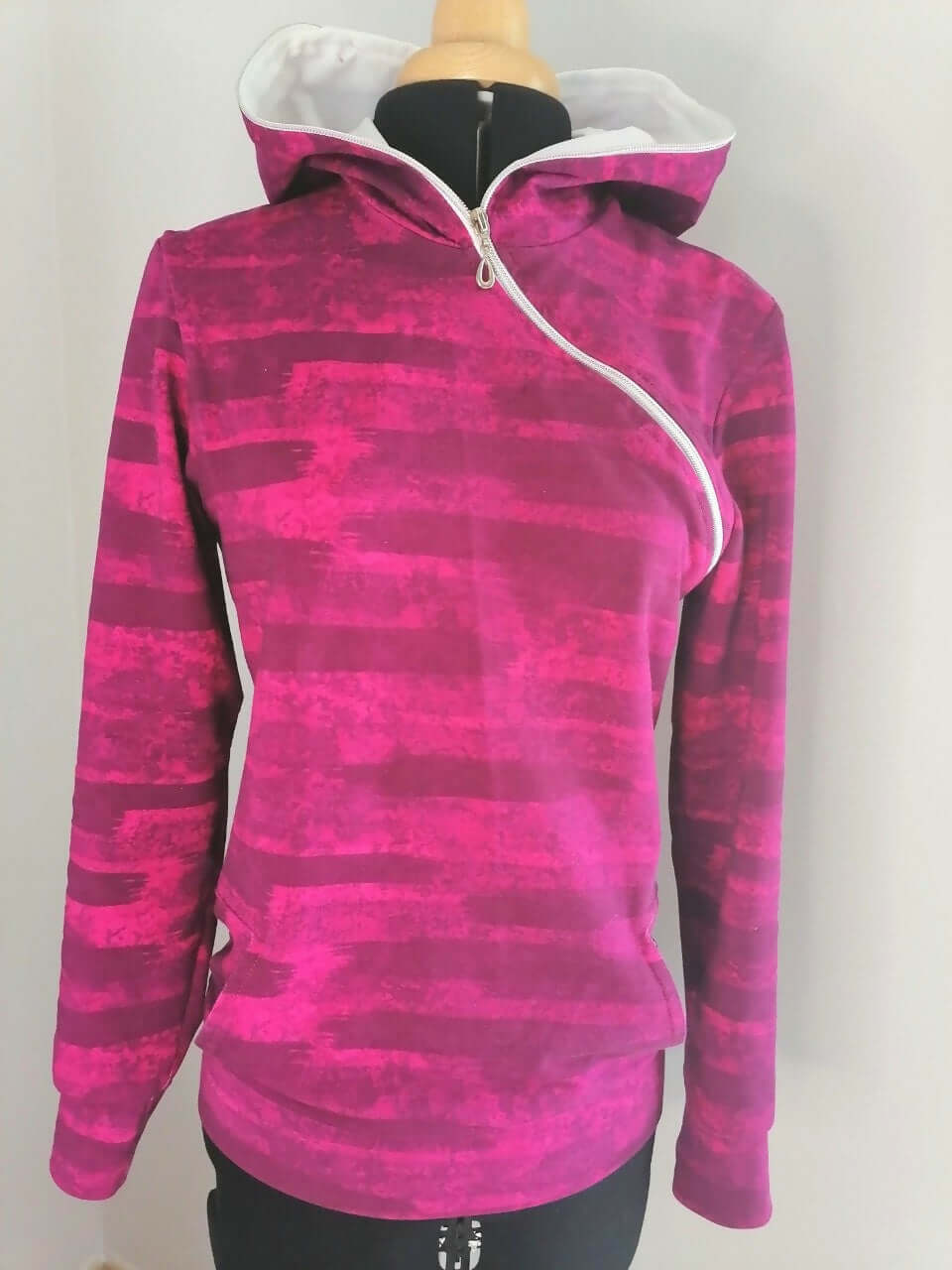 LE SWEAT ZIP ZAG du XS au XXL en rose avec zip en diagonale, style original et poches kangourou facultatives.