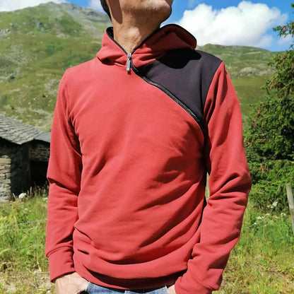 LE SWEAT ZIP ZAG du XS au XXL en couleur rouge avec zip diagonal et capuche dans un cadre naturel.