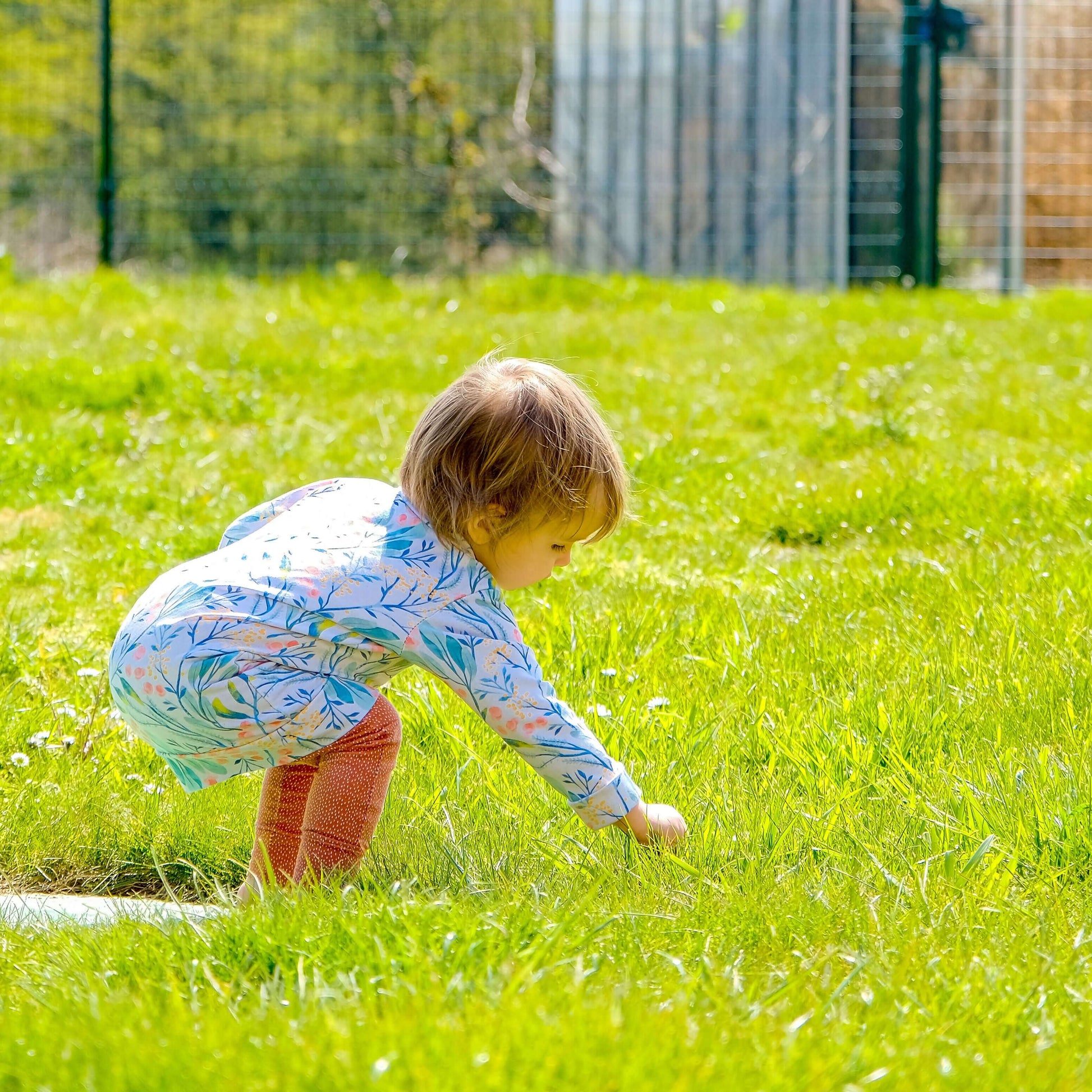 Enfant jouant dans l'herbe, portant un vêtement cousu avec LITCHI : t-shirt, sweat et robe en un patron, patron de couture pdf à télécharger.