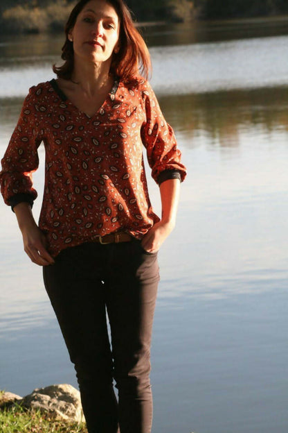 La Blouse CYCLADINE du 34 au 52 portée par une femme près d'un plan d'eau, style sport-chic et élégant.