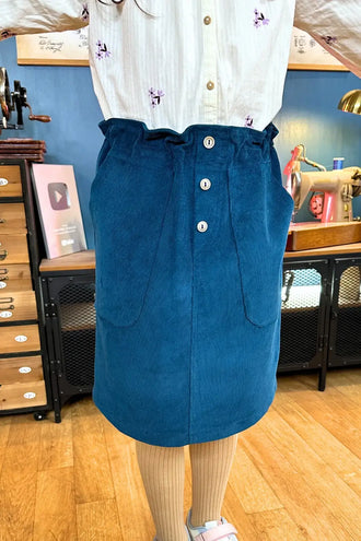 La Jupe Chabichou en 11 tailles, patron de couture pdf à télécharger pour enfants, jupe bleue présentée sur mannequin à la maison.