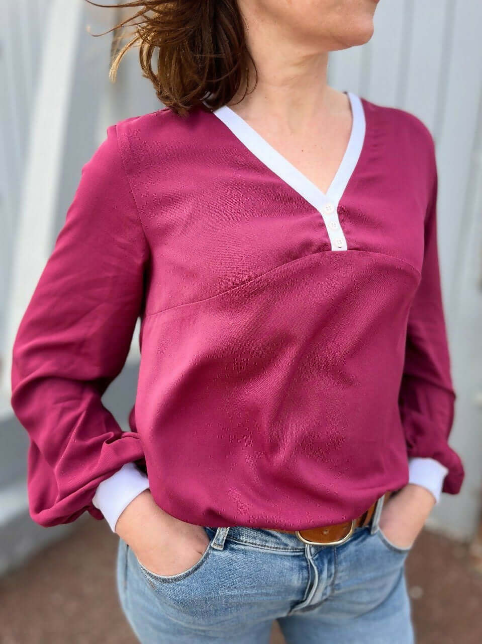 La blouse COLYNE du 34 au 48 en tissu bordeaux, style chic sportif, avec encolure en V et boutons.