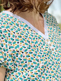La blouse COLYNE du 34 au 48, avec encolure V et boutons, idéale pour un look sport chic.
