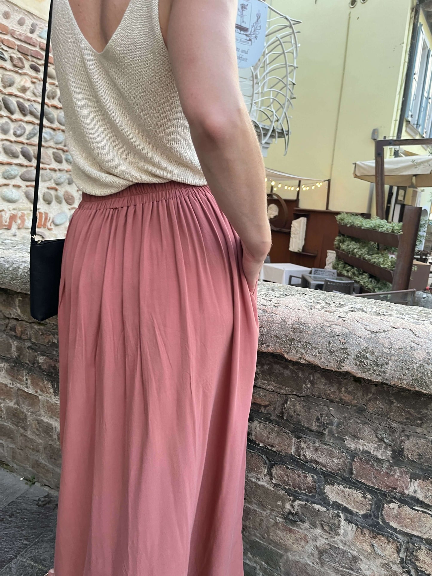 Femme portant La jupe EOLYA du 32 au 52, patron de couture pdf à télécharger, vue de dos avec ceinture élastiquée et tissu fluide.