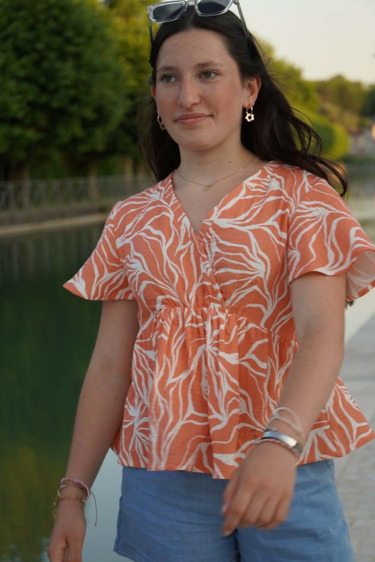 Femme portant la robe (ou blouse) Sorelle du 32 au 52 en tissu imprimé, style léger et élégant.