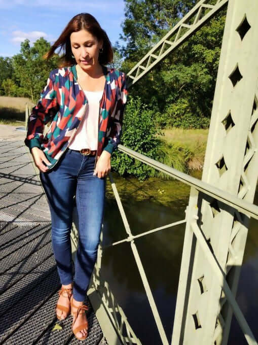 La veste BLOOMY du 34 au 46 portée par une femme sur un pont, légère et féminine, idéal pour un look décontracté.