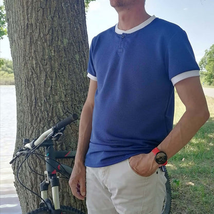 Le Polo Enjoy Homme du 38 au 50 porté en extérieur près d'un vélo, idéal pour un look décontracté.