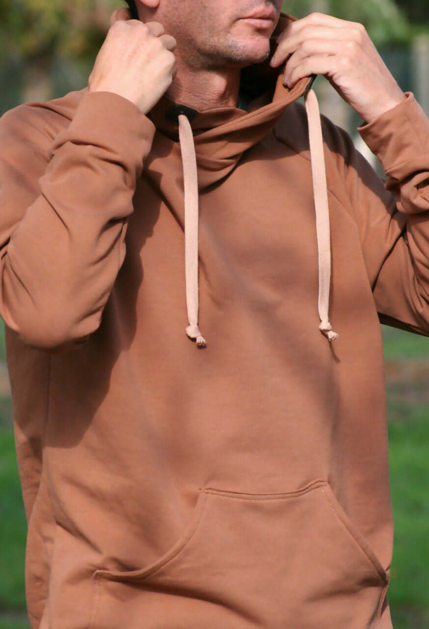 Le SWEAT FLEX adulte mixte du S au XL porté en extérieur avec une capuche et des cordons stylés.