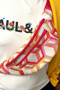 Patron de couture à télécharger pour sac banane coloré géométrique porté sur t-shirt blanc fleuri et sweat jaune