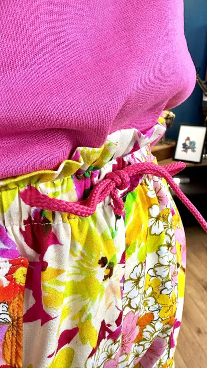 Gros plan sur le Short Figuette en 13 tailles avec un cordon rose et un tissu floral coloré, patron de couture PDF à télécharger.
