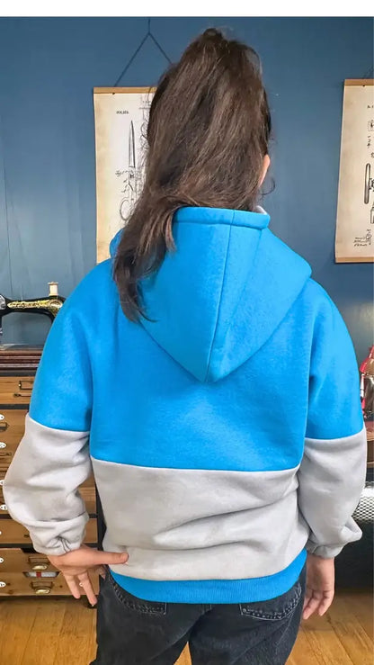 Enfant portant Le Sweat Rollot pour enfant, un patron de couture PDF à télécharger, disponible en 9 tailles, vu de dos en bleu-gris.
