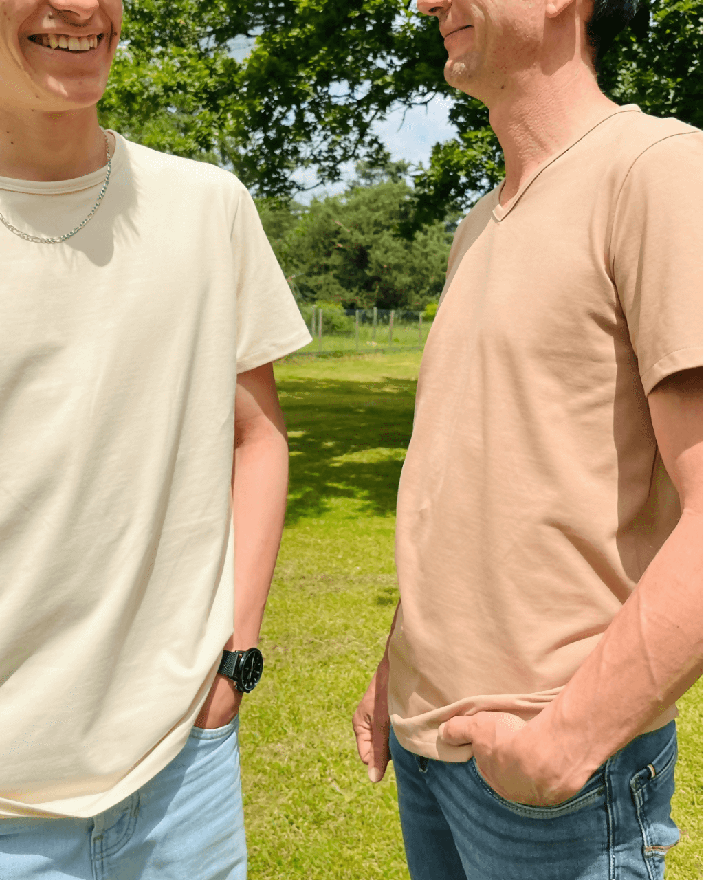 Le T-shirt Raoul du 38 au 54 porté par deux hommes, un en col rond et l'autre en col V, dans un cadre verdoyant.