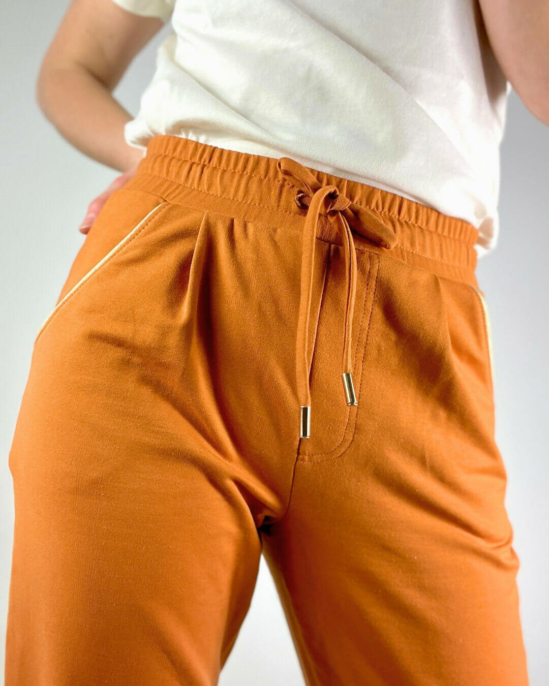 Le pantalon Sprint du 32 au 52, patron de couture pdf à télécharger, en tissu orange avec taille haute et coupe confortable.