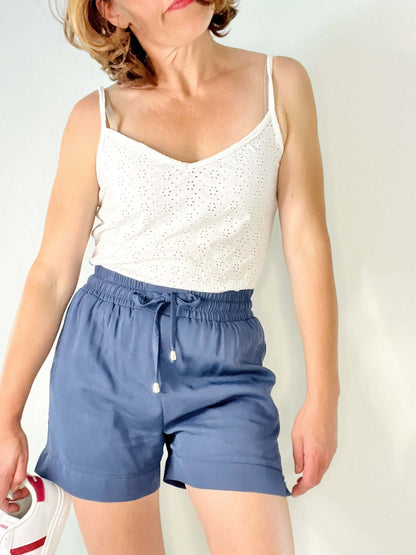 Modèle portant Le pantalon ou short Springy du 32 au 52 avec ceinture élastiquée, patron de couture pdf à télécharger en bleu.