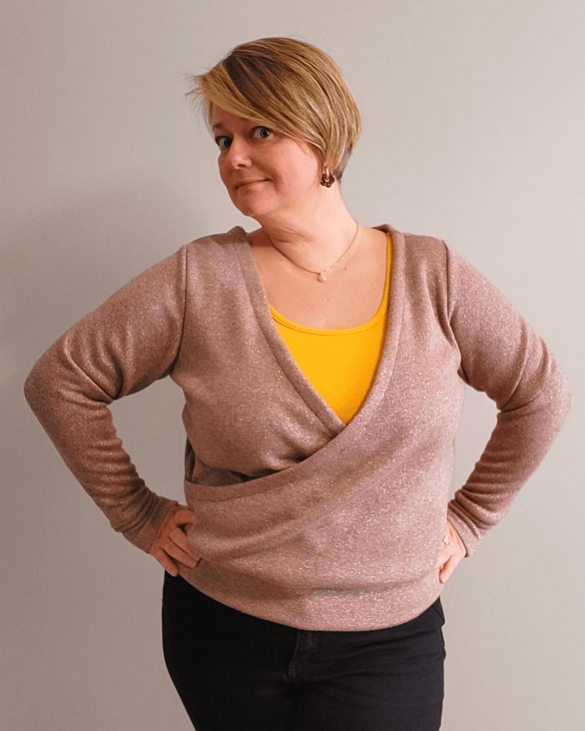 Le pull Axia du 32 au 52 en cache-cœur beige, patron de couture pdf à télécharger, femme posant avec assurance.