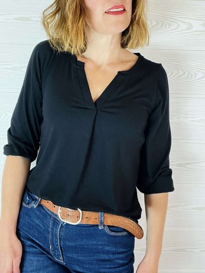 Femme portant le top Maly du 32 au 52, patron de couture pdf à télécharger, en jersey noir avec col en V et manches 3/4.