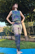 Legging FIT en tissu à motifs, associé à un débardeur, sur fond de jardin. Patron de couture pdf à télécharger.