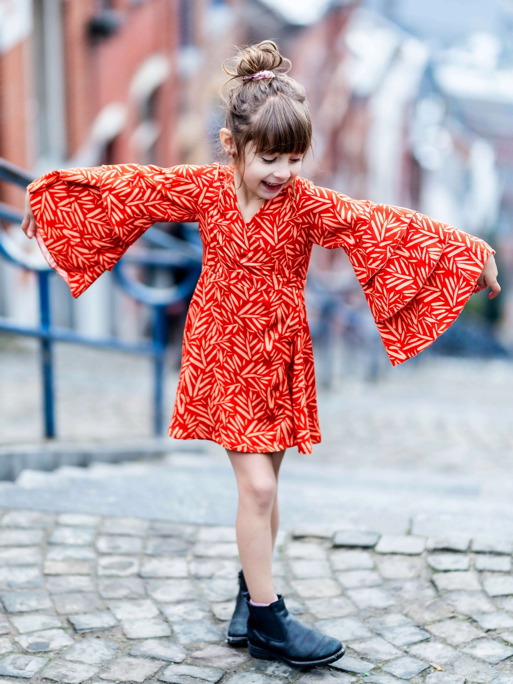 Petite fille portant MANDARINE : la robe / blouse portefeuille en rouge, patron de couture pdf à télécharger disponible.