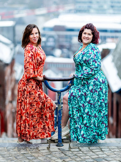 Deux femmes portant la MANDARINE : la robe / blouse portefeuille dans un paysage urbain enneigé, patron de couture pdf à télécharger.