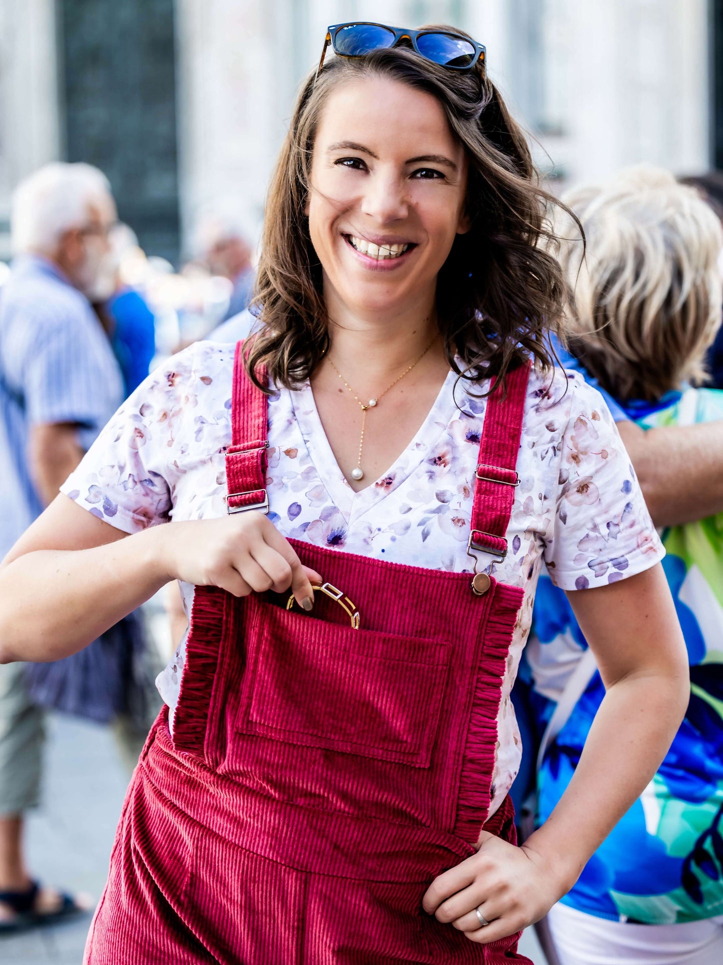 Femme souriante portant une salopette rouge, idéale pour un tuto de couture avec patron PDF.