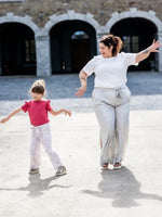 NASHI - Le pantalon palazzo, patron de couture pdf à télécharger, femme portant un pantalon fluide avec un enfant dansant dehors.