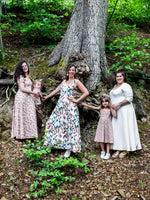 Quatre femmes portant des robes d'été élégantes dans une forêt, illustrant le design du patron de couture pdf à télécharger NECTARINE - La robe fendue.