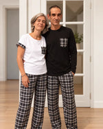 Couple portant le Patron PDF Pyjama NYX, haut blanc et noir avec poche écossaise, bas écossais noir et blanc