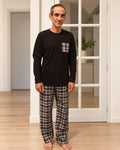 Homme portant le Patron PDF NYX pyjama modulable, ensemble noir et carreaux noir blanc, pieds nus en intérieur