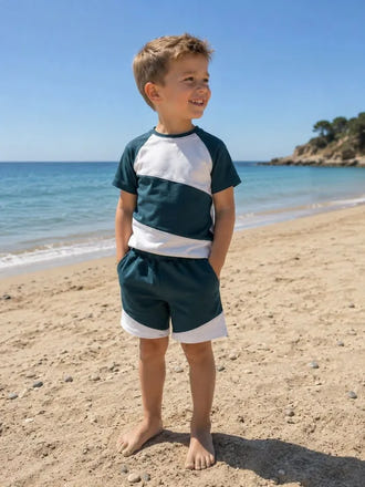 Enfant portant le Patron PDF Pack T-shirt/Short LOULOU et TWIST, coloris bleu marine et blanc, à la plage
