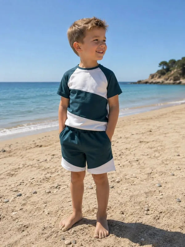 Enfant portant le Patron PDF Pack T-shirt/Short LOULOU et TWIST, coloris bleu marine et blanc, à la plage