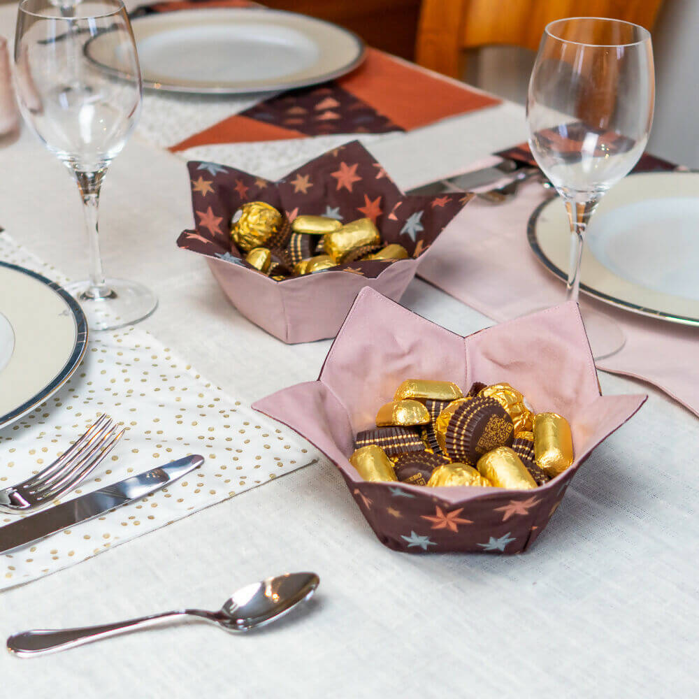 PACK Table de Noël 2, 4 patrons et tutoriels - corbeilles étoile colorées avec des bonbons sur une table festive.