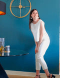 Femme portant le Pantalon Alta, décontracté et élégant, patron de couture pdf à télécharger, fond bleu avec décoration intérieure.